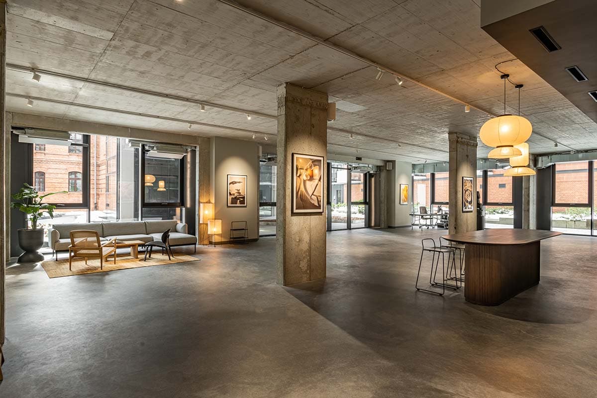 Post-industrial modern interior space showing a spacious area with concrete floors, exposed ceiling, and stylish furniture